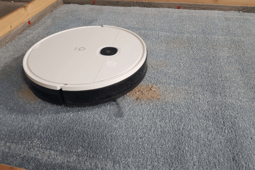 Yeedi Vac Hybrid saugt im Reinigungstest Sand auf einem Teppich.